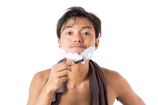 シェービングの泡でヒゲを剃る男性の画像